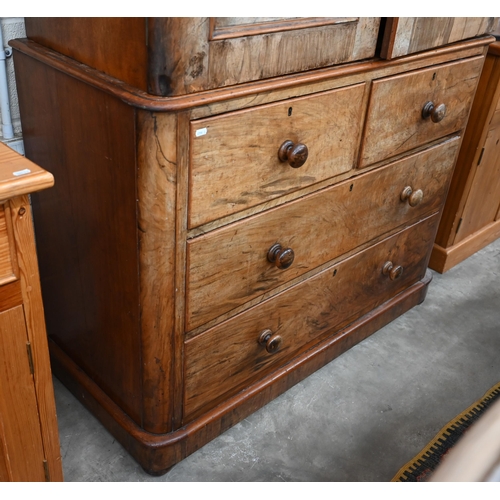 80 - A Victorian stained mahogany (imitation walnut) linen press with arch panelled doors enclosing four ... 