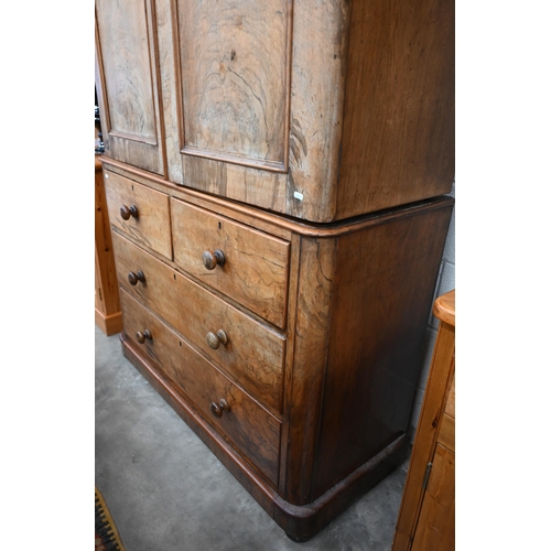 80 - A Victorian stained mahogany (imitation walnut) linen press with arch panelled doors enclosing four ... 