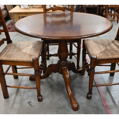 82 - A circular oak breakfast table on baluster turned column and triform supports, 90 cm diameter x 74 c... 