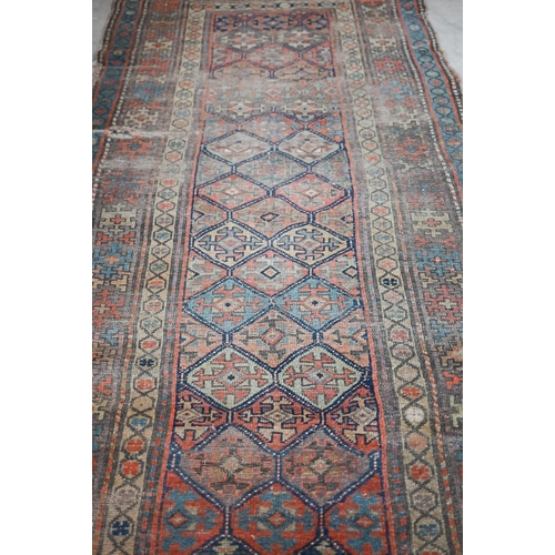 93 - Antique Kurdish runner of geometric design on red ground with repeating borders, very worn, 290 x 12... 