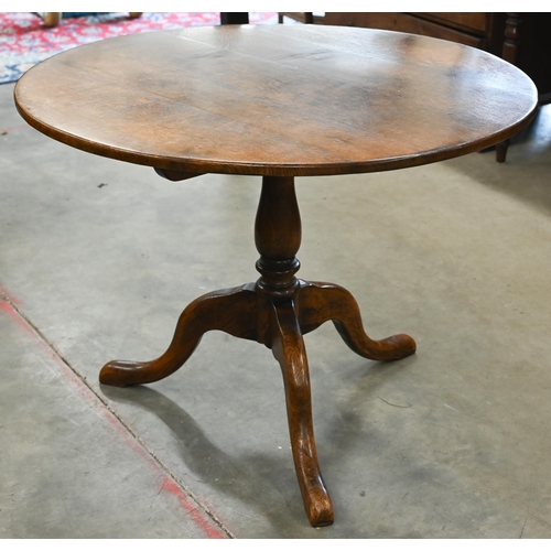 96 - A circular oak breakfast table on turned column and triform supports, 100 cm diam x 75 cm high