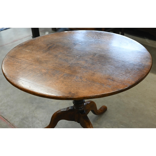 96 - A circular oak breakfast table on turned column and triform supports, 100 cm diam x 75 cm high