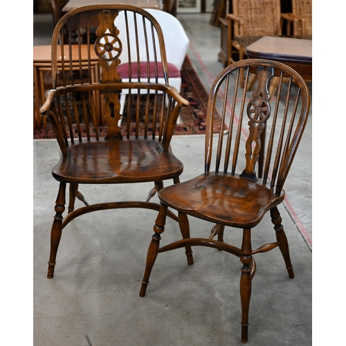 97 - An elm and ash wheelback Windsor chair with crinoline front stretcher to/w matching side chair (2)