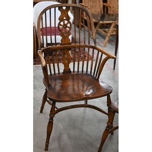 97 - An elm and ash wheelback Windsor chair with crinoline front stretcher to/w matching side chair (2)