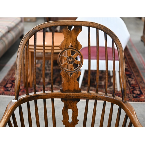 97 - An elm and ash wheelback Windsor chair with crinoline front stretcher to/w matching side chair (2)