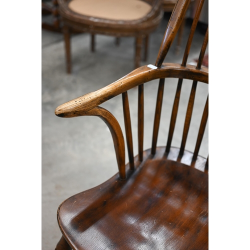 97 - An elm and ash wheelback Windsor chair with crinoline front stretcher to/w matching side chair (2)