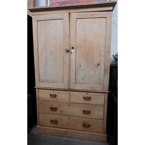 91 - An antique pine linen press with panelled doors enclosing shelved interior on chest base with two sh... 