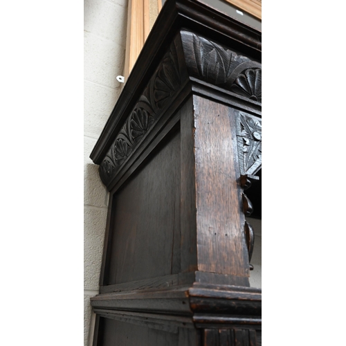 92 - # An antique carved oak hall cupboard with panelled doors over two drawers, a/f, 138 x 55 x 195 cm h... 