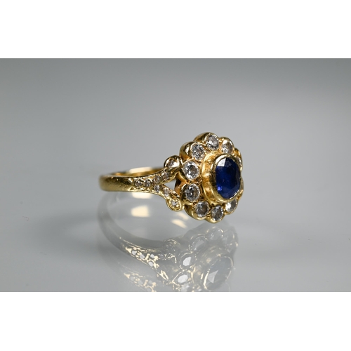 230 - A sapphire and diamond cluster ring, the oval collet set sapphire surrounded by ten brilliant cut di... 