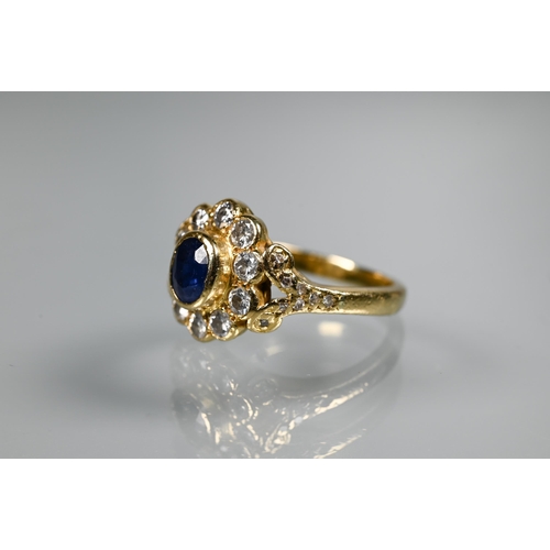 230 - A sapphire and diamond cluster ring, the oval collet set sapphire surrounded by ten brilliant cut di... 