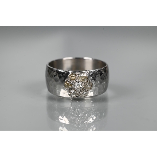 231 - A contemporary 9ct white gold wide band with hammered finish, set with seven-stone diamond cluster, ... 