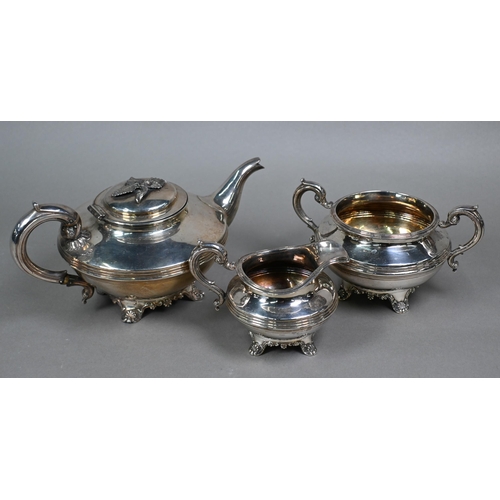 106 - A William IV silver three piece tea service of compressed circular form with scroll handles and reed... 
