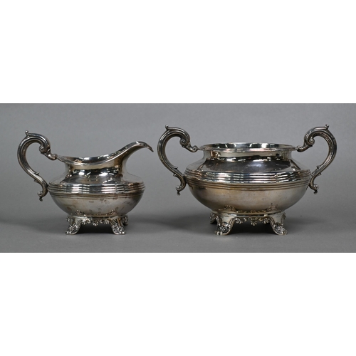 106 - A William IV silver three piece tea service of compressed circular form with scroll handles and reed... 