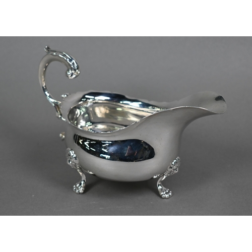 118 - An Edwardian silver pot-bellied sauce boat in the Georgian taste, with shaped rim and scroll handle,... 