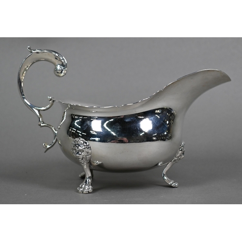 118 - An Edwardian silver pot-bellied sauce boat in the Georgian taste, with shaped rim and scroll handle,... 