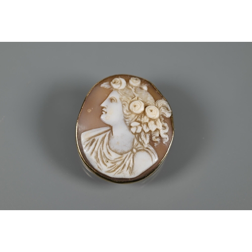 198 - An oval shell cameo brooch featuring female with elaborate hair, in 9ct yellow gold plain mount with... 