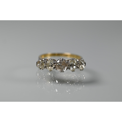 203 - A five stone diamond ring, the alternate oval and round diamonds in yellow and white metal setting s... 