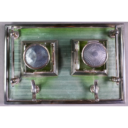 25 - An Art Deco electroplated inkstand with two square cut glass bottles flanked by rails, on framed gre... 