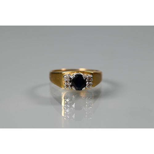 262 - An 18ct yellow gold ring set central oval dark blue sapphire with two small diamonds to each side, s... 