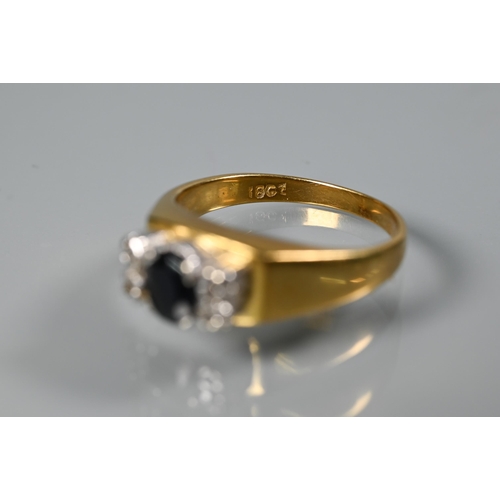 262 - An 18ct yellow gold ring set central oval dark blue sapphire with two small diamonds to each side, s... 