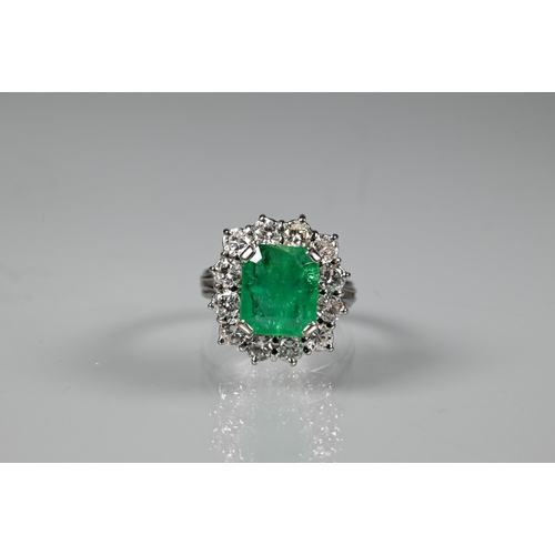 270 - A rectangular cluster ring, the central natural emerald surrounded by twelve brilliant cut diamonds,... 