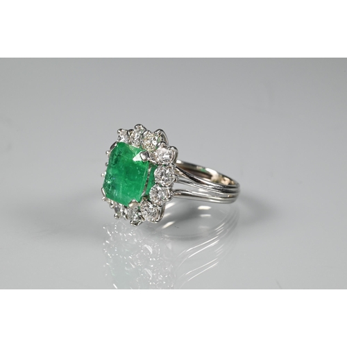 270 - A rectangular cluster ring, the central natural emerald surrounded by twelve brilliant cut diamonds,... 