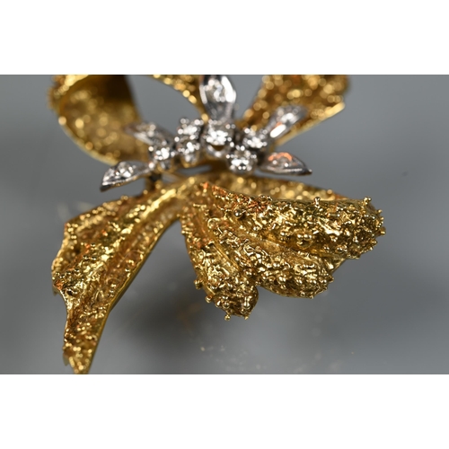 281 - An 18ct yellow gold brooch of textured form, set with mixed cut diamonds, in the form of a bow, appr... 