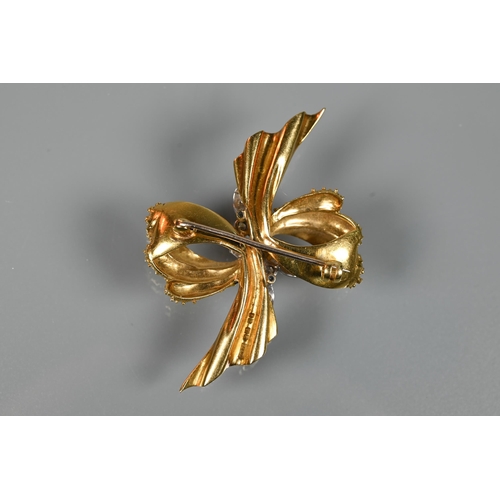 281 - An 18ct yellow gold brooch of textured form, set with mixed cut diamonds, in the form of a bow, appr... 