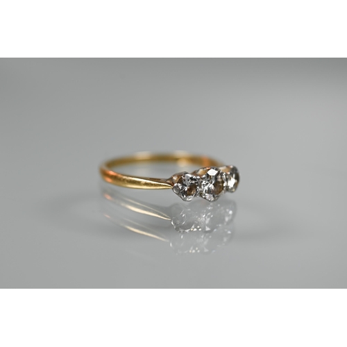 285 - A three-stone claw set diamond ring, yellow and white gold stamped 18ct and plat, size P 1/2