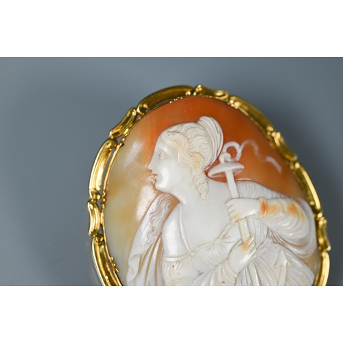 288 - A large Victorian cameo brooch featuring St Philomena, in yellow metal scroll mount, 6.5 x 5.5 cm