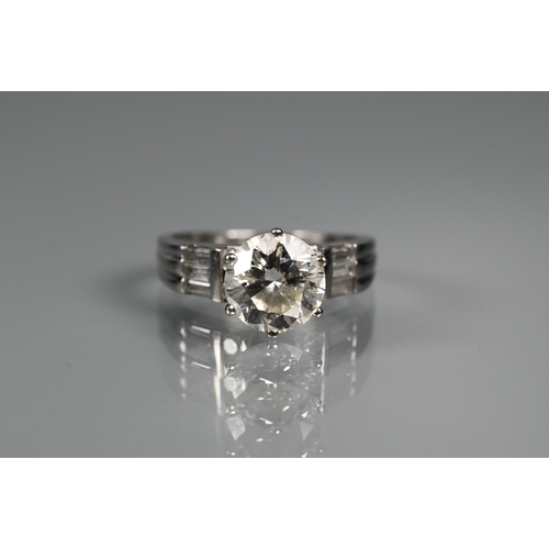 290 - A diamond ring, the central round brilliant cut stone with four round brilliant cut diamonds to each... 