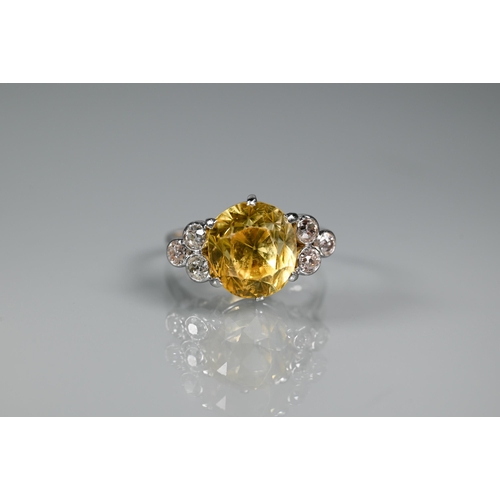 290A - An early 20th century yellow sapphire and diamond ring, the central oval yellow sapphire with three ... 