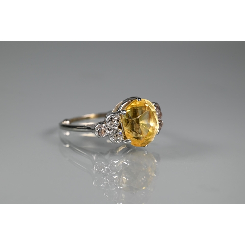 290A - An early 20th century yellow sapphire and diamond ring, the central oval yellow sapphire with three ... 