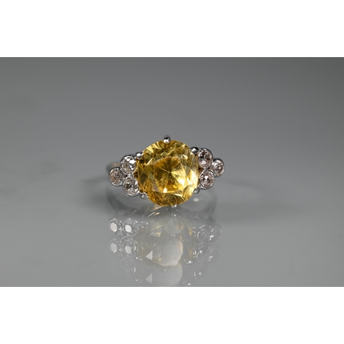 290A - An early 20th century yellow sapphire and diamond ring, the central oval yellow sapphire with three ... 