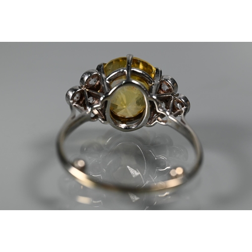 290A - An early 20th century yellow sapphire and diamond ring, the central oval yellow sapphire with three ... 