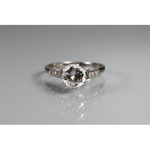 295 - A diamond ring, the central round brilliant cut diamond with three milgrain set diamonds to each sho... 