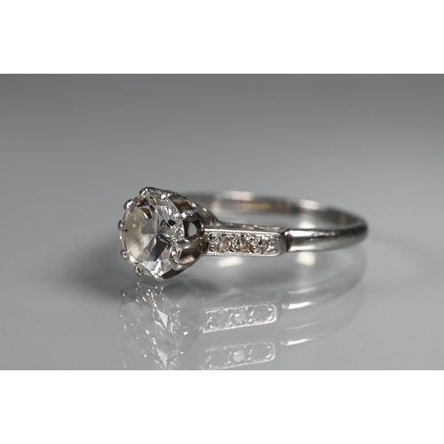 295 - A diamond ring, the central round brilliant cut diamond with three milgrain set diamonds to each sho... 