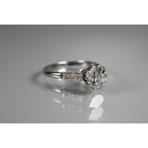 295 - A diamond ring, the central round brilliant cut diamond with three milgrain set diamonds to each sho... 