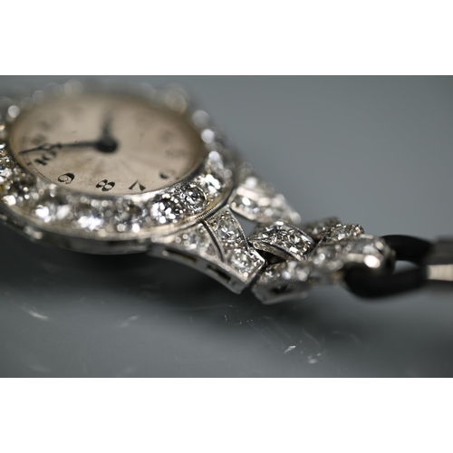 305 - A platinum and diamond set ladies wristwatch, the Art Deco style diamond set surround with engine tu... 