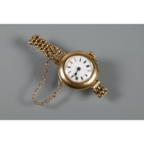 317 - An Edwardian 15ct gold wristwatch with Swiss movement and white enamelled dial within a broad bezel,... 