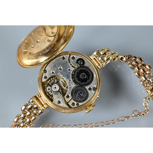 317 - An Edwardian 15ct gold wristwatch with Swiss movement and white enamelled dial within a broad bezel,... 