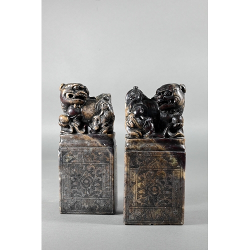 361 - A pair of early 20th century Chinese soapstone desk seals carved with Buddhistic guardian lions and ... 