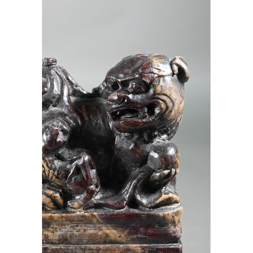 361 - A pair of early 20th century Chinese soapstone desk seals carved with Buddhistic guardian lions and ... 