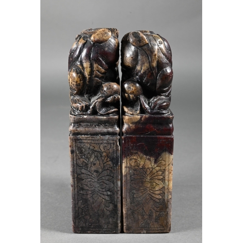 361 - A pair of early 20th century Chinese soapstone desk seals carved with Buddhistic guardian lions and ... 