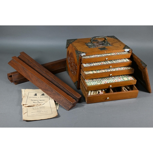 381 - A Chinese Mah Jong set, the carved wooden and brass mounted case with two carry handles and sliding ... 