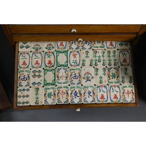 381 - A Chinese Mah Jong set, the carved wooden and brass mounted case with two carry handles and sliding ... 