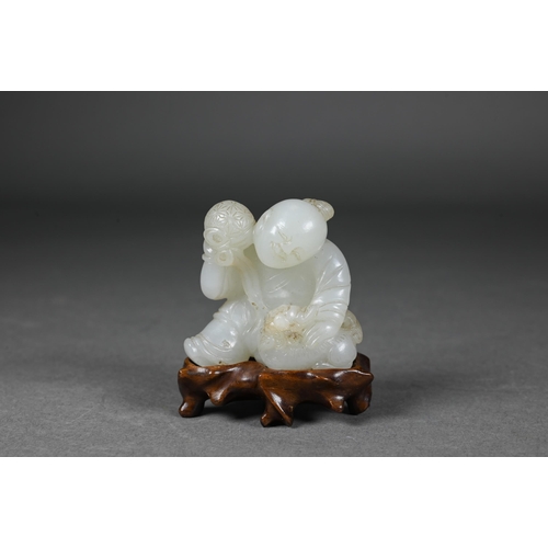 384 - An 18th century Chinese jade carving of a boy and karashisi playing with a ribbon tied brocade ball,...