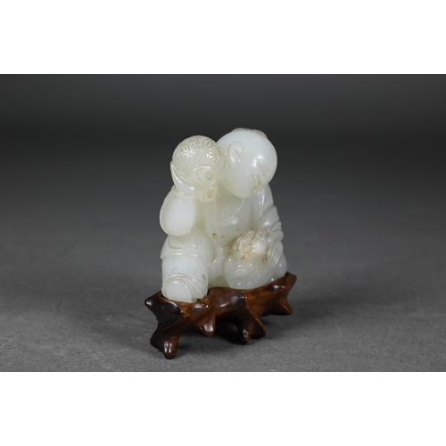 384 - An 18th century Chinese jade carving of a boy and karashisi playing with a ribbon tied brocade ball,... 