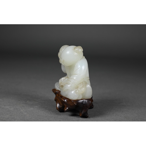 384 - An 18th century Chinese jade carving of a boy and karashisi playing with a ribbon tied brocade ball,... 