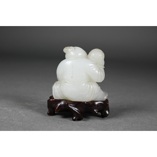 384 - An 18th century Chinese jade carving of a boy and karashisi playing with a ribbon tied brocade ball,... 